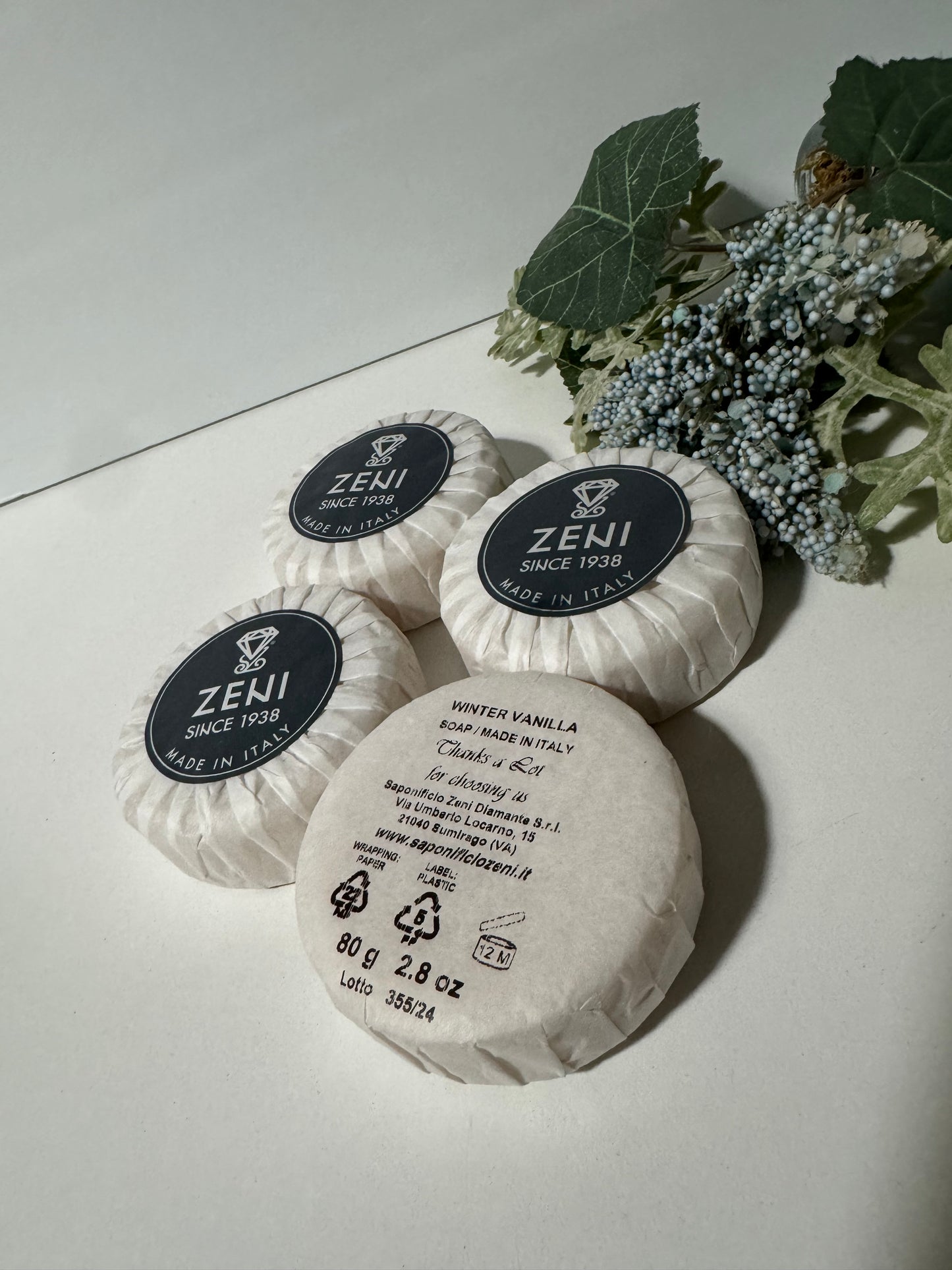 Winter Vanilla round soap bars unboxed, arranged flat with greenery, showcasing elegant packaging