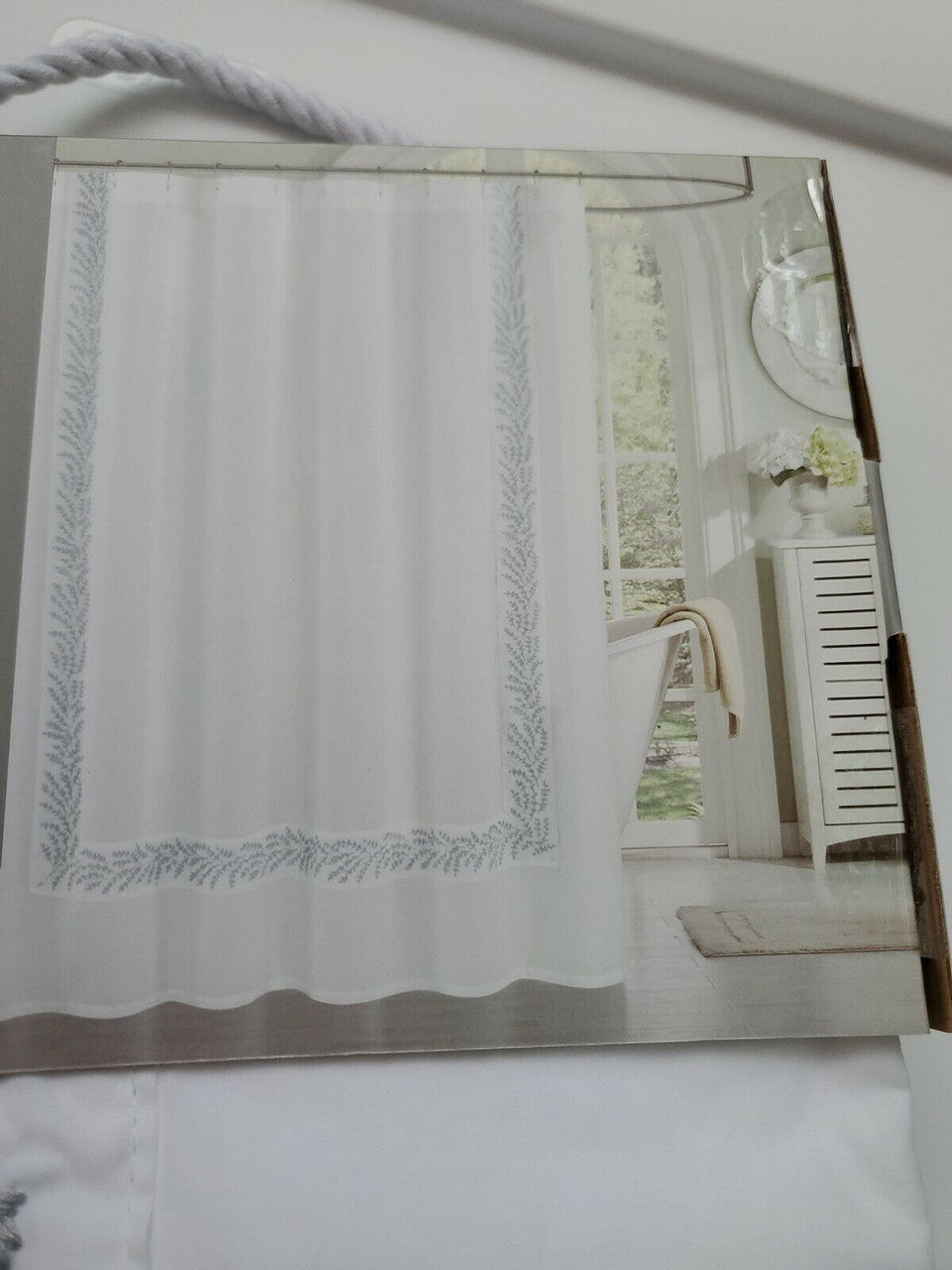 Folded white 100% cotton embroidered shower curtain from The Texture Collection shown in retail packaging