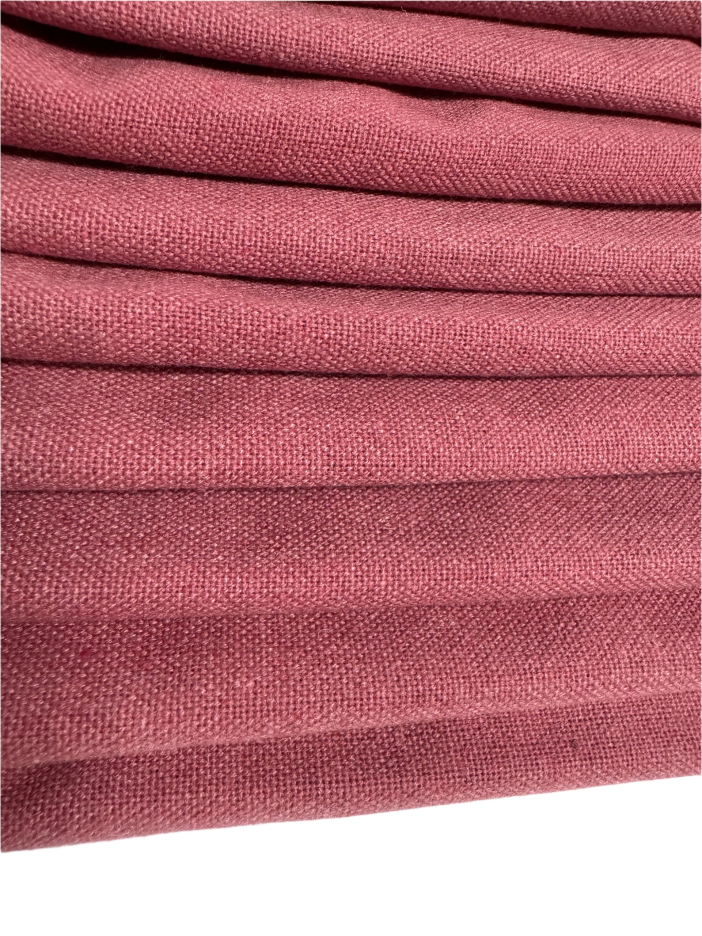 Close-up shot of a stack of 8 blush pink cotton napkins, neatly folded and showcasing the smooth, soft texture of the fabric. The napkins feature a refined hemstitch design and mitered corners, exuding elegance and sophistication