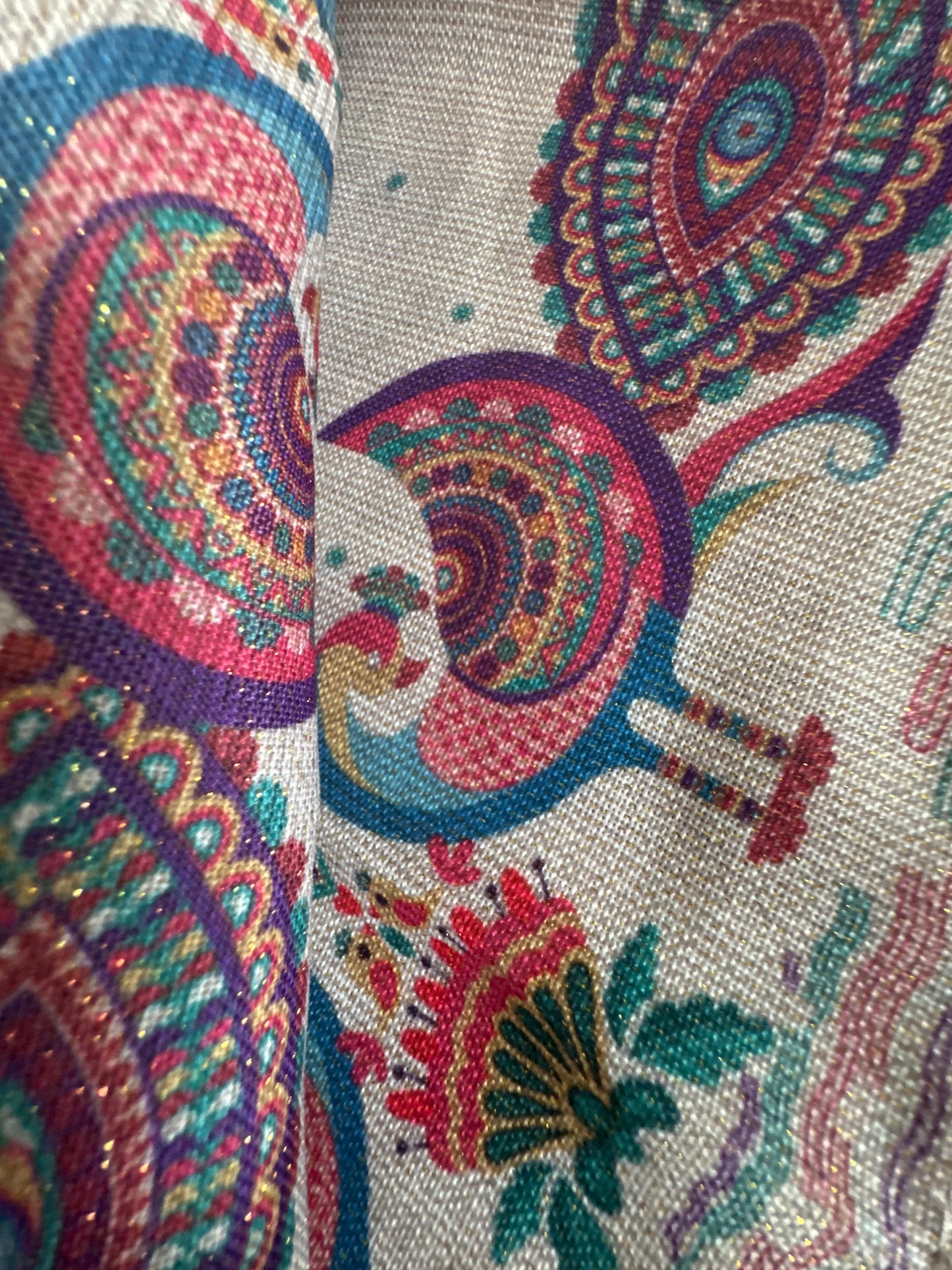 Close-up of a set of 8 vibrant, peacock-themed napkins with intricate lurex and printed designs. Each napkin is elegantly crafted from polyester with metallic fibers, showcasing a festive and luxurious touch with a rich color palette