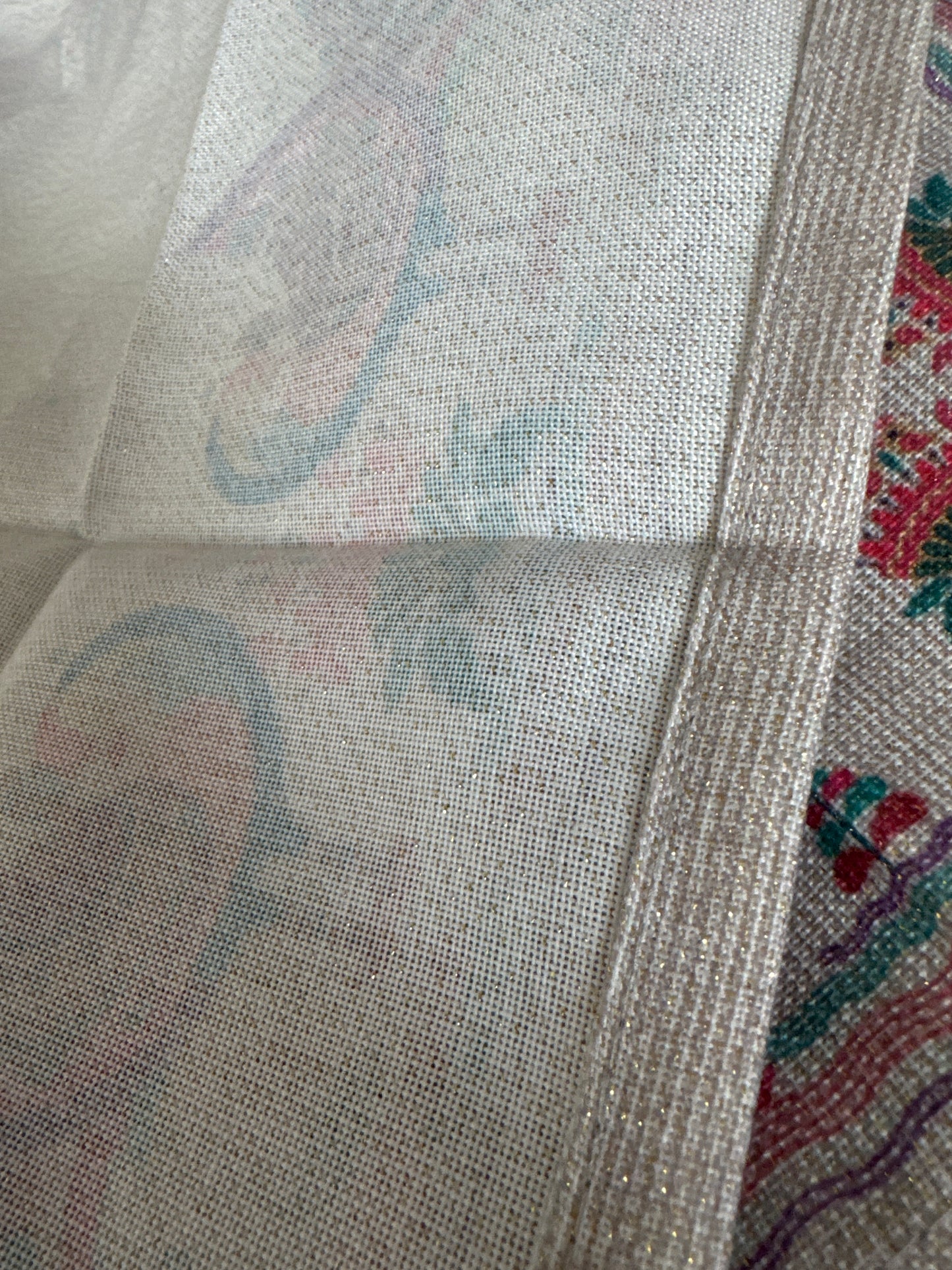 Close-up of a set of 8 vibrant, peacock-themed napkins with intricate lurex and printed designs. Each napkin is elegantly crafted from polyester with metallic fibers, showcasing a festive and luxurious touch with a rich color palette